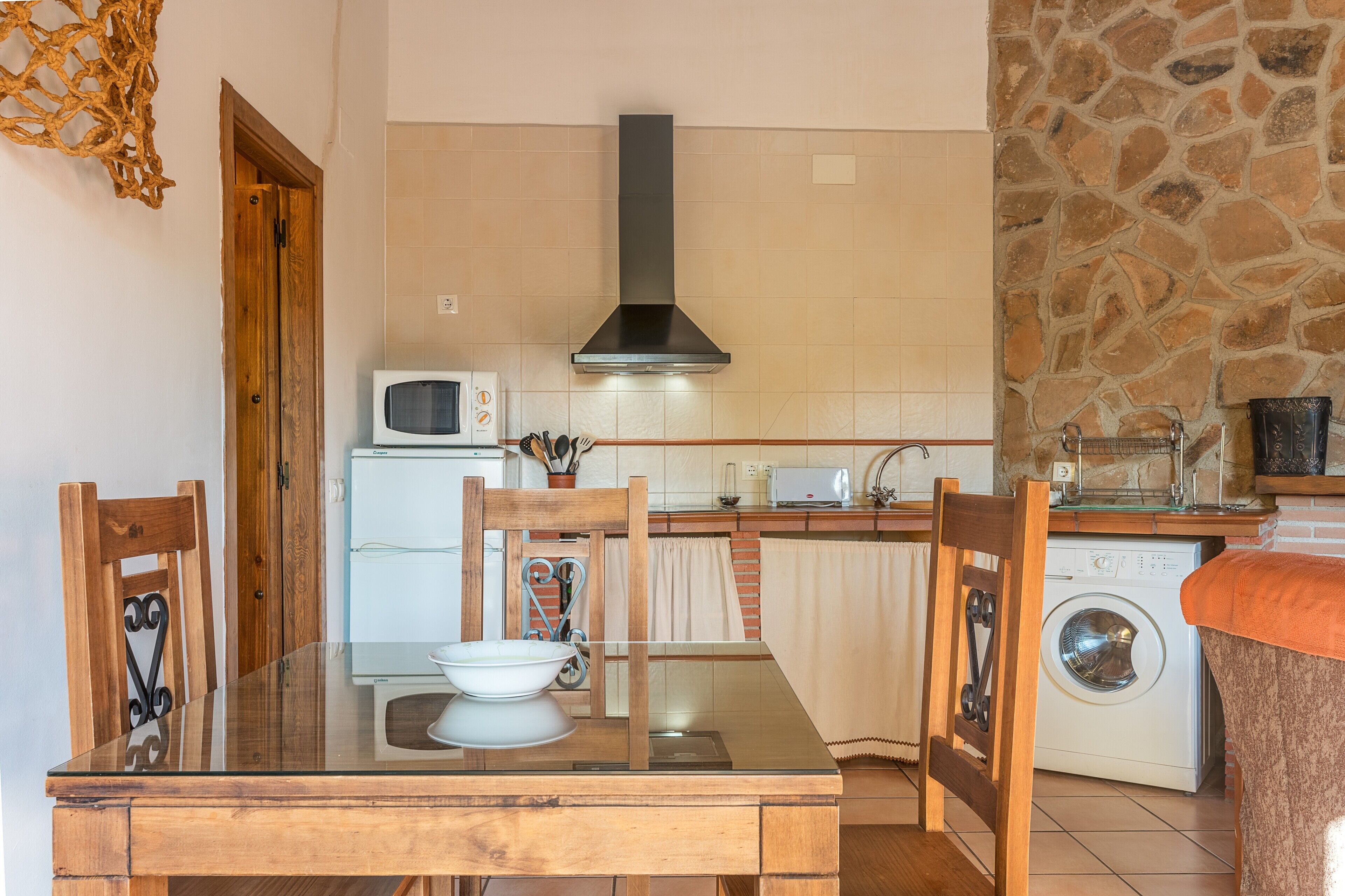 A compact kitchen with a microwave, stove, and washing machine.