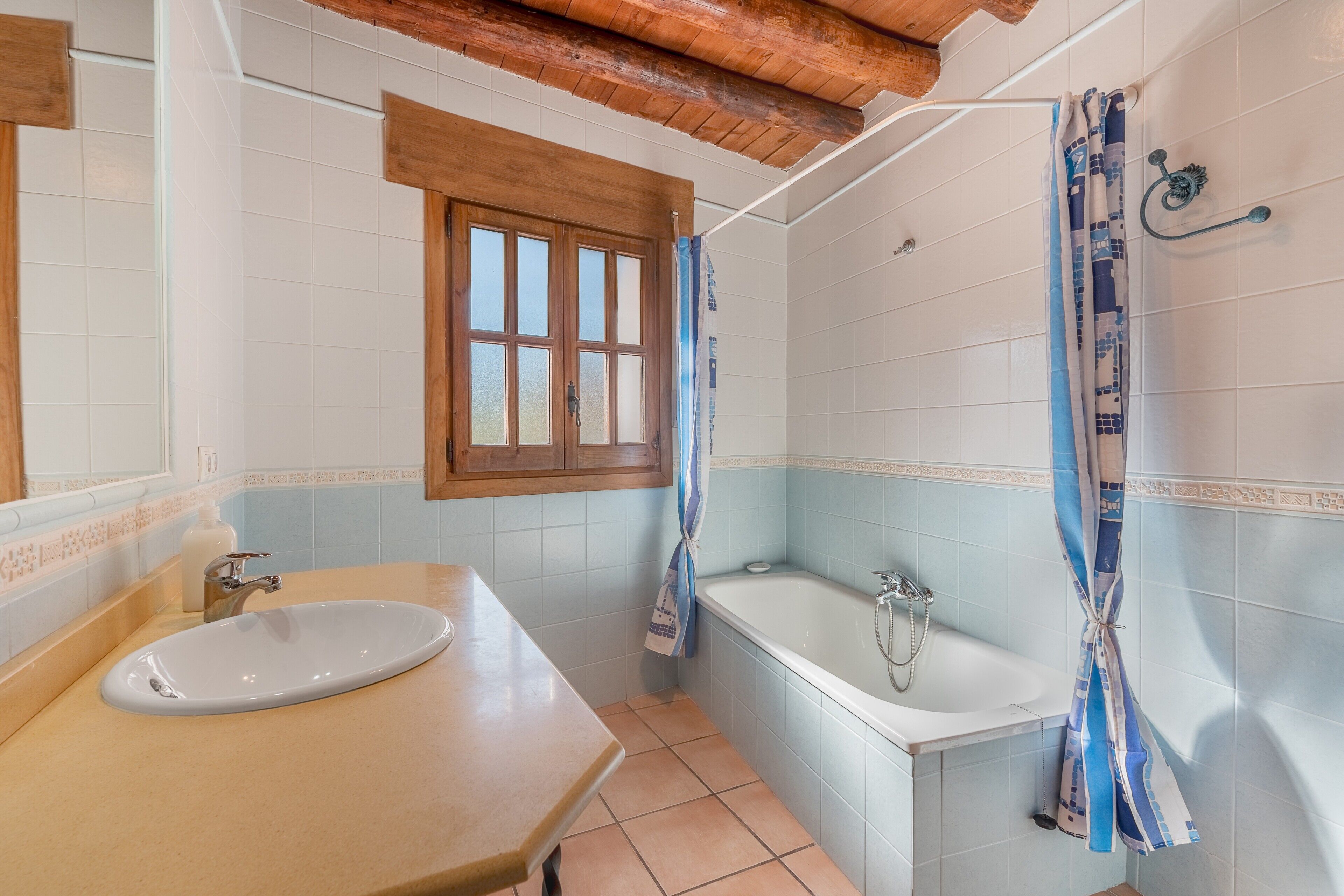 Une salle de bain équipée d’un lavabo, d’une baignoire et d’un rideau de douche.