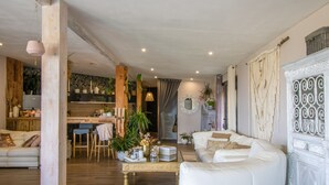 A spacious living room with a white sofa, a wooden coffee table, and a dining area with a kitchen in the background. - Villa 'Liliekaena' with Sea View, Wi-Fi, and Air Conditioning (Albitreccia)