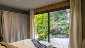 A bedroom with a large window, a bed, and a view of a garden. - Villa 'Liliekaena' with Sea View, Wi-Fi, and Air Conditioning (Albitreccia)