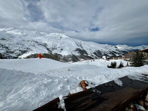 A snow-covered mountain landscape with a ski resort and buildings in the background.