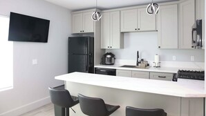 A modern kitchen with a central island, black refrigerator, and stainless steel appliances. - Charming 1-bedroom house with WiFi, AC in peaceful Santa Clarita Brand New (Santa Clarita)