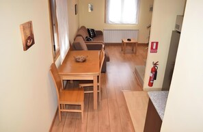 A cozy living area with a wooden dining table, a sofa, and a small side table. - Apartment 'Casa Requias 1' with Lake View, Shared Garden and Wi-Fi (Requiás)