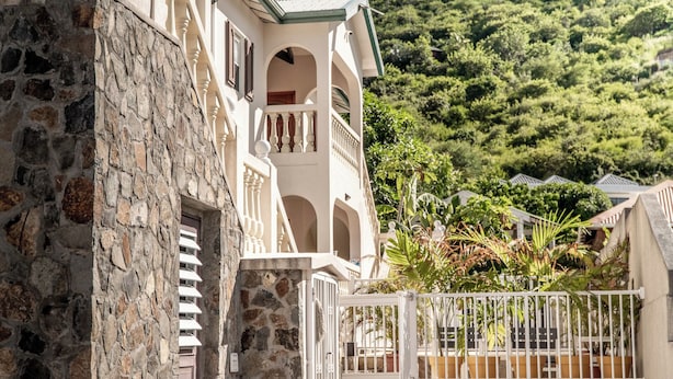 A stone building with a balcony and a gate.