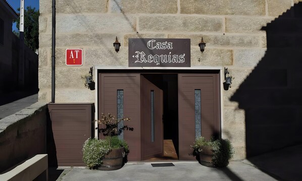 Une entrée d’immeuble avec une enseigne indiquant « Casa Beovias » et un symbole AT rouge.