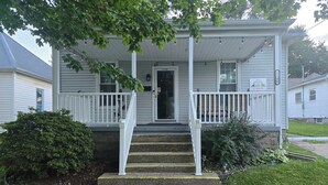 A two-story house with a porch, a front door, and a staircase leading to the entrance. - Charming 2-bedroom bungalow with WiFi and AC in serene Mount Carmel (Mount Carmel)
