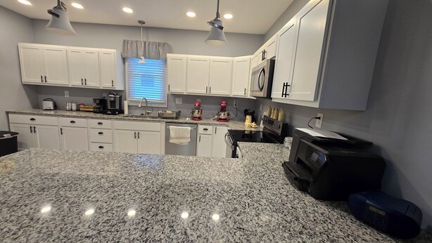 A modern kitchen with white cabinets, granite countertops, and stainless steel appliances. - Charming 2-bedroom bungalow with WiFi and AC in serene Mount Carmel (Mount Carmel)