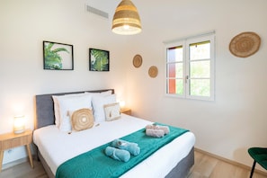 A neatly made bed with a teal blanket, a bedside lamp, and a woven pendant light. - Villa 'Zeruko Izarra, Grand Standing' with Mountain View, Wi-Fi and Air Conditioning (Sare)