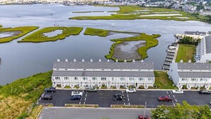 Een hotel met een parkeerplaats en uitzicht op een meer met groene zones.