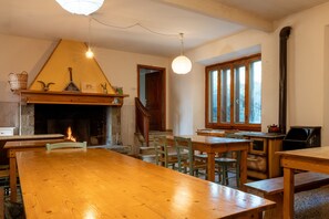 Un coin repas agrémenté d’une cheminée, de meubles en bois et offrant une vue sur l’extérieur.