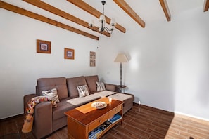 Un salon avec un canapé marron, une table basse en bois et une lampe.