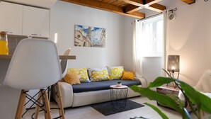 A modern living room with a sofa, a coffee table, and a plant. - Rooms and apartments Paese (Split)