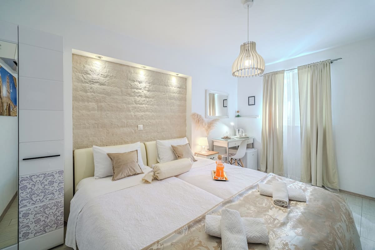 Une chambre à coucher moderne avec un grand lit, des tables de chevet, un bureau et une chaise.