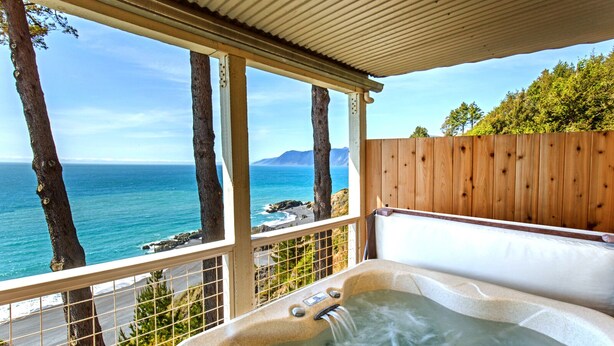 Un jacuzzi con vistas al océano y a las montañas.