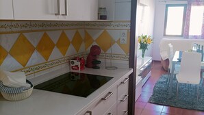 Una cocina con gabinetes blancos, encimera negra y salpicadero con diseño.