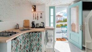 A kitchen with a wooden countertop, a sink, and a stove. There is a window with a view of a building and a door leading to an outdoor area. - 'Casa Hélène' with Sea Views, Shared Pool and Wi-Fi (Fasnia)