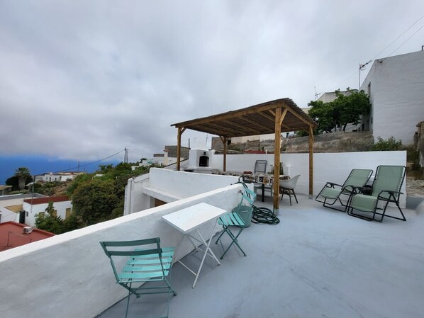 A rooftop terrace with a pergola, outdoor seating, and a view of the surrounding buildings. - 'Casa Hélène' with Sea Views, Shared Pool and Wi-Fi (Fasnia)