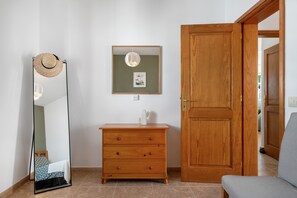 Une pièce comprenant une commode en bois, un miroir, une porte et un banc.