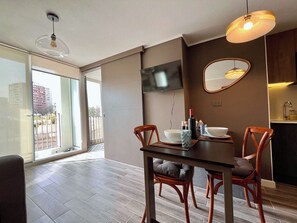 Un comedor moderno con una mesa, sillas y un televisor montado en la pared.