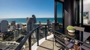 Enjoy breathtaking views of the coastal city from this apartment's expansive windows and balcony.