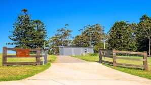 A fenced property with a building and a signboard.