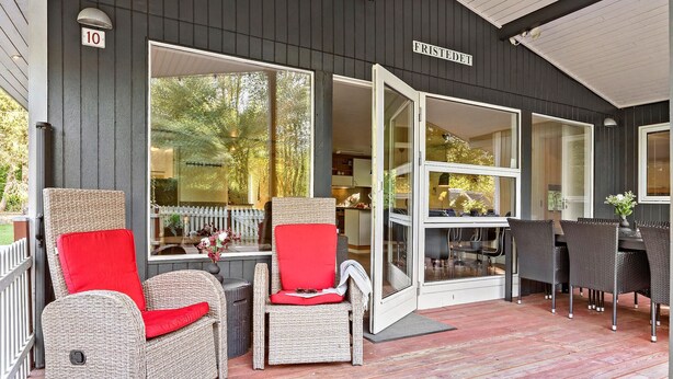 A covered porch with wicker furniture, a dining table, and a view of the interior. - 3 bedroom pet friendly home in Toftlund (Toftlund)