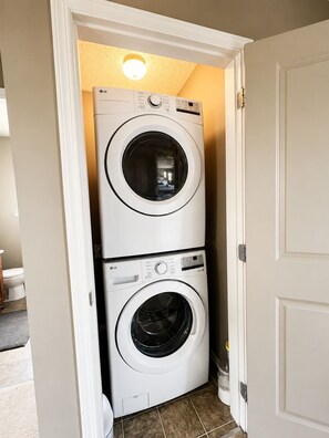 A laundry room with two stacked front-loading washing machines. - Beautiful Place to Stay (Victoria)