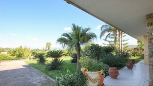 Une terrasse agrémentée de plantes en pot, une vue sur le paysage et un mur en pierre.