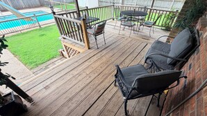 A wooden deck with outdoor furniture, a pool, and a grassy yard. - 3-bedroom w/pool and all the comforts of home in Muscle Shoals-recording capital (Muscle Shoals)