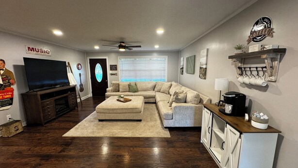 A living room with a sectional sofa, a coffee maker, and a television. - 3-bedroom w/pool and all the comforts of home in Muscle Shoals-recording capital (Muscle Shoals)