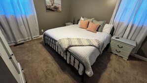 A bedroom with a bed, nightstands, a dresser, and a painting on the wall. - 3-bedroom w/pool and all the comforts of home in Muscle Shoals-recording capital (Muscle Shoals)
