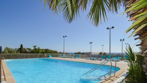 A swimming pool with clear blue water, surrounded by a white fence, and equipped with multiple light poles. - 3 bedroom gorgeous home in Cervione (Cervione)