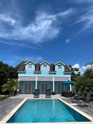 Una casa de dos pisos con piscina delantera.
