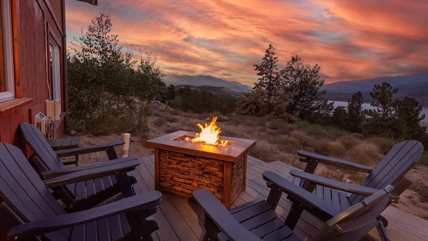 A deck with a fire pit and Adirondack chairs overlooking a scenic landscape. - Stunning Mountain & Lake Views 3BR Cabin with Hot tub (Twin Lakes)