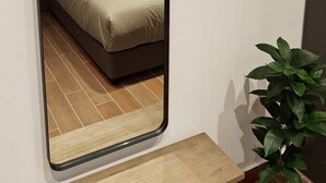 Ein Schlafzimmer mit einem Bett, einem großen Spiegel und einem Gemälde über dem Bett.