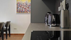 Eine moderne Küche mit schwarzer Arbeitsplatte, Edelstahlgeräten und minimalistischem Design.