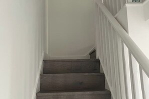 Un escalier avec des marches en bois et des rampes blanches.