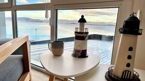 A room with a view of a body of water, a small table with a mug, and a lighthouse model. - Studio with great view of the Beagle Channel (Ushuaia)