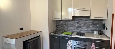 Een koelkast, een oven, een kookplaat, een koffiezetapparaat/waterkoker