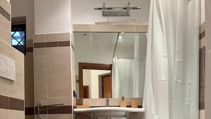 A bathroom with a toilet, bidet, and sink.