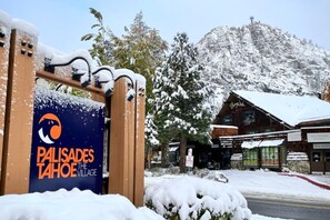 A sign for 'Palisades Tahoe The Village' with a mountain backdrop.