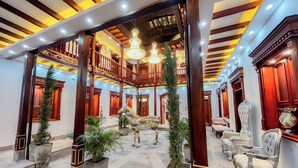A spacious lobby with a high ceiling, ornate wooden columns, and a chandelier. - Hotel & Rooftop King Experience by David (Quito)