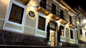 A historic building with a prominent entrance, a balcony, and a sign indicating it is a hotel. - Hotel & Rooftop King Experience by David (Quito)