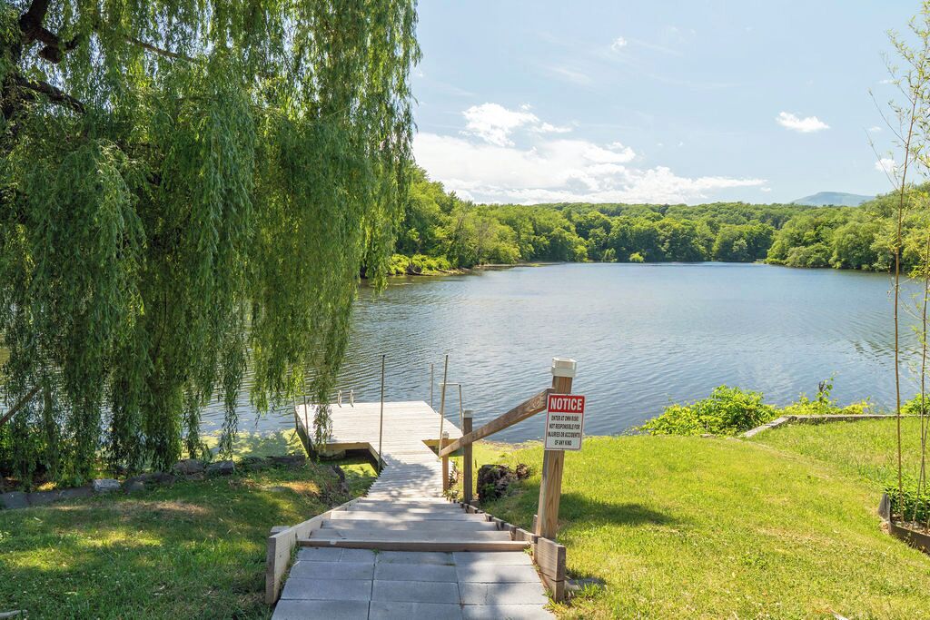 Un escalier en bois menant à une jetée au bord d’un lac, avec un panneau d’information.
