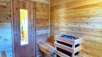 A wooden sauna room with benches and a bench with a storage compartment.