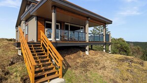 A modern house with a wooden staircase leading to a balcony. - 360⁰ Views at The Feather (Victoria)