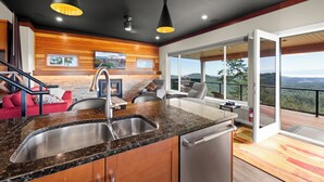 A modern kitchen with granite countertops, stainless steel appliances, and a large window overlooking a scenic view. - 360⁰ Views at The Feather (Victoria)