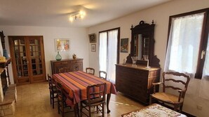 A dining area with a table and chairs, a fireplace, and a wooden cabinet.