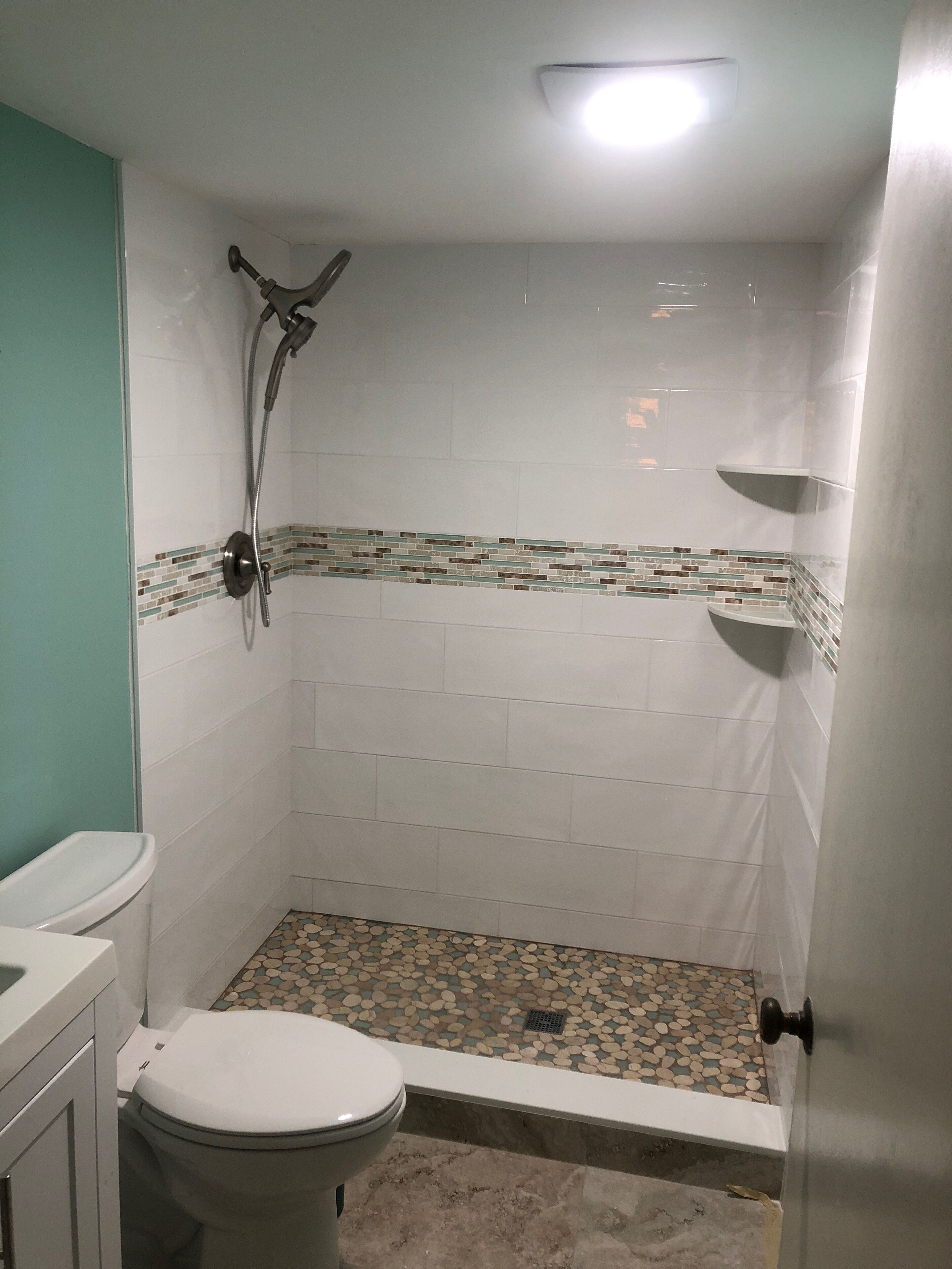 A small bathroom with a shower, toilet, and sink.