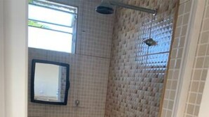 A small bathroom with a shower, a sink, and a mirror. - Studio (unfurnished) Monthly (Neópolis Natal)